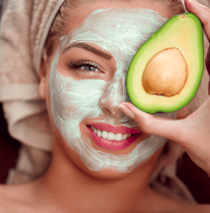 Woman with a green face  mask and avocado